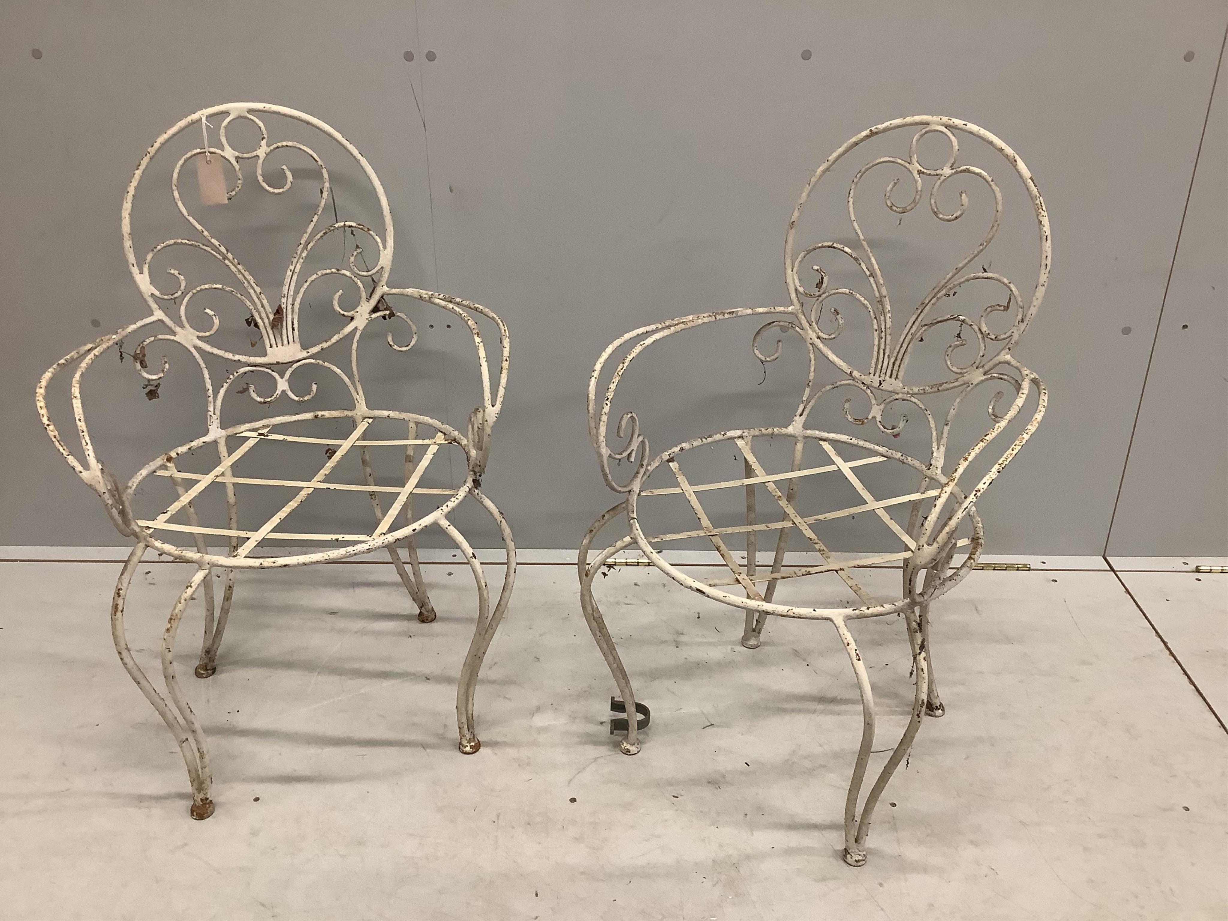 A pair of vintage wrought iron garden chairs, width 53cm, depth 46cm, height 85cm. Condition - poor to fair